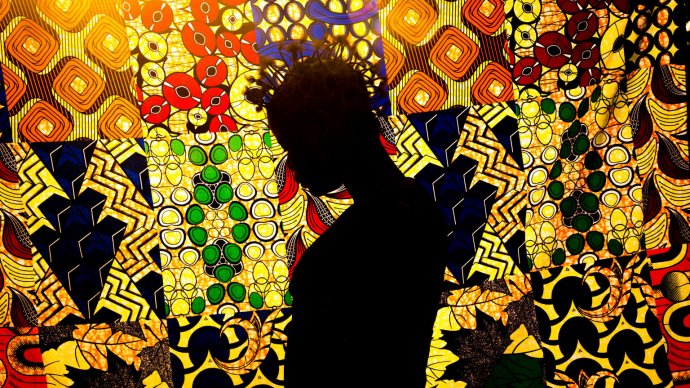 Silhouette of a young woman against a colorful background